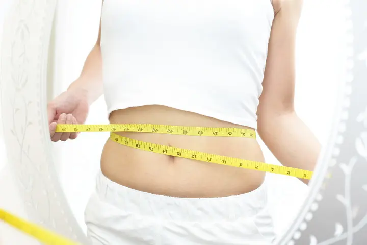 ウエストを測る女性