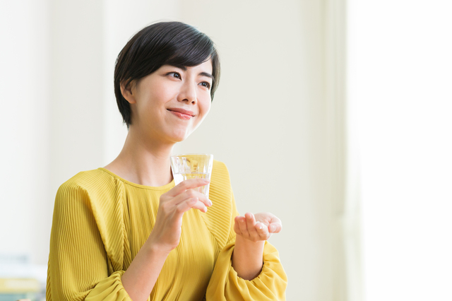 薬を飲む女性