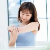 二の腕を見る女性